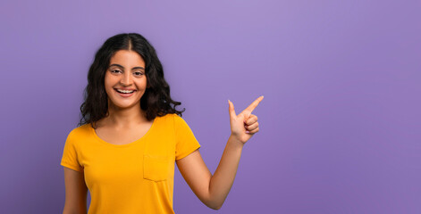 Happy young indian lady pointing at free space