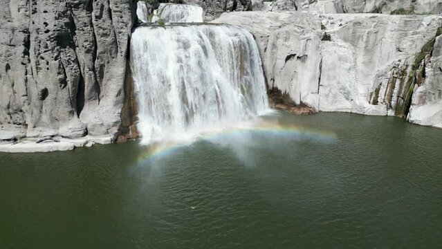 Aerial view of a beautiful rocky waterfall on a bright sunny day