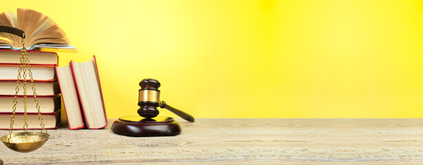 Law concept - Open law book, Judge's gavel, scales on table in a courtroom or law enforcement office. Banner