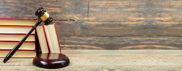 Law concept - Open law book, Judge's gavel on table in a courtroom or law enforcement office. Banner
