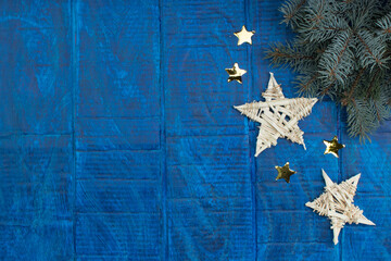 Christmas background. gold stars decorations on blue wooden background. Top view copy space. Snow frame