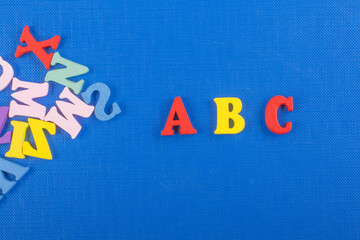 ABC word on blue background composed from colorful abc alphabet block wooden letters, copy space for ad text. Learning english concept.