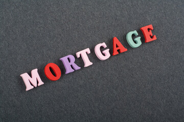 MORTGAGE word on black board background composed from colorful abc alphabet block wooden letters, copy space for ad text. Learning english concept.