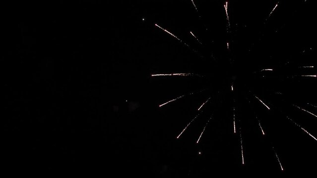 Firework explosions with glowing traces and stars in sky at nighttime holiday