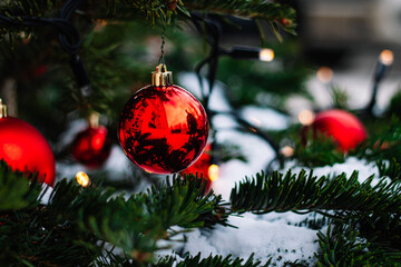 Red Christmas balls and garlands on branch.