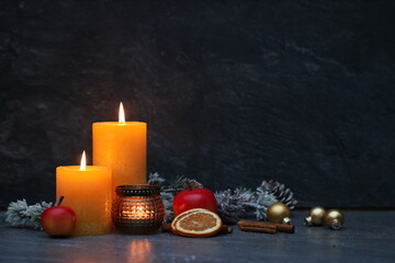 Christmas decorations with burning candles in the dark with space for text.