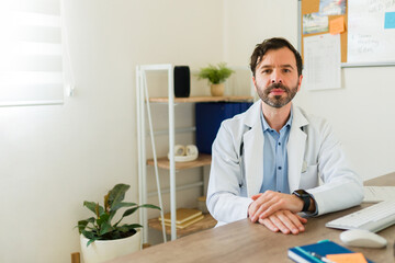 Fototapeta premium Hispanic doctor working at his office with a lab coat