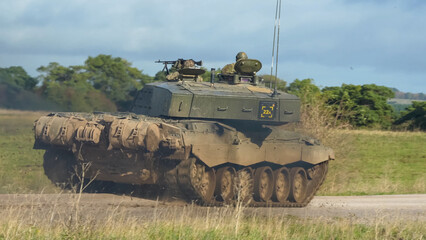 Commander and gunner directing a British army FV4034 Challenger 2 ii main battle tank moving along...