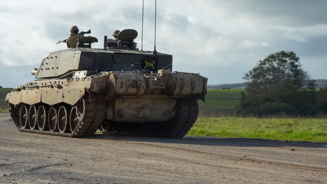 close-up of Commander and gunner directing a British army FV4034 Challenger 2 ii main battle tank moving along a dirt track, on a military exercise, Wiltshire UK