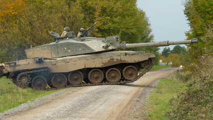 close-up of Commander and gunner directing a British army FV4034 Challenger 2 ii main battle tank as it rises to cross over a dirt track, on a military exercise, Wiltshire UK