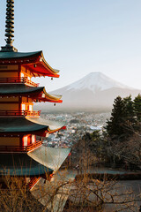 Obraz premium Picture Title: Serene Dawn at Mount Fuji. A pagoda stands in vibrant contrast to the serene backdrop of Japan's iconic Mount Fuji bathed in the warm glow of sunrise.