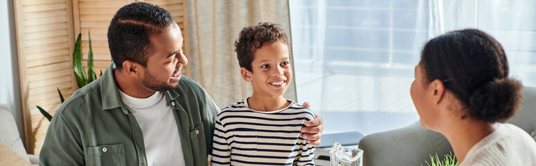 beautiful african american family in casual homewear looking lovingly at each other, banner