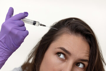 millennial woman using mezoroller with needles against hair loss,on scalp.girl with pills blisters...