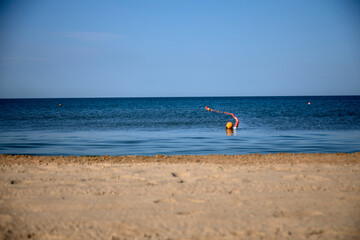 Obraz premium view of the blue black sea from the beach, summer, wind, creates drawings on the sand. lots of shells