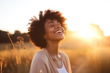Backlit Portrait of calm happy smiling free black woman with closed eyes enjoys a beautiful moment life on the fields at sunset