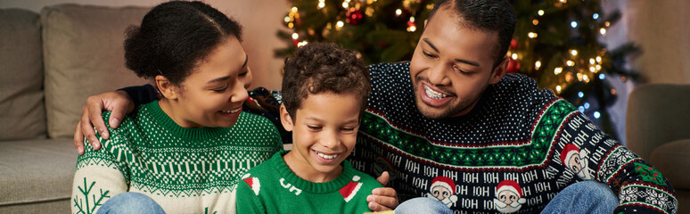 happy african american family in warm festive sweaters spending time together, Christmas, banner