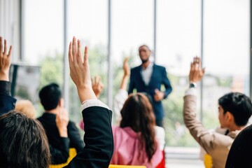 In a conference and convention at a corporate event businesspeople raise their hands to ask questions and vote. The meeting training seminar and discussions emphasize teamwork and collaboration. - obrazy, fototapety, plakaty