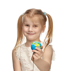 Blonde baby 6 years old, in a white dress shows a globe
