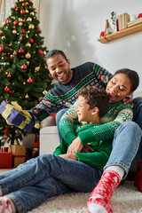 happy african american family spending time together on Christmas morning exchanging presents