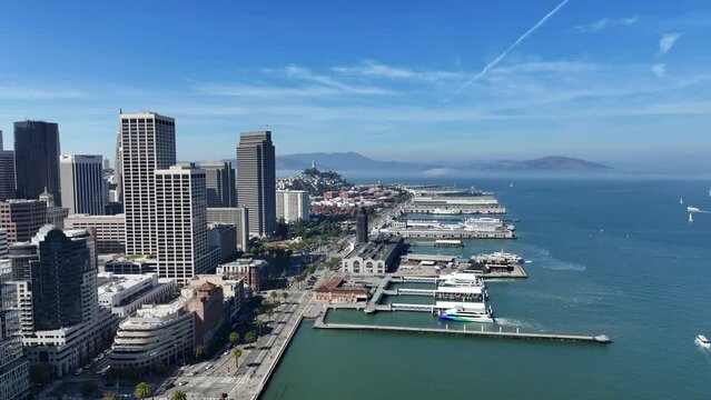 San Francisco, USA, left backward flight from "The Embarcadero and Ferry Building" to Skyscraper Skyline of "South of Market"(SoMA) district and famous Salesforce Tower - aerial video footage