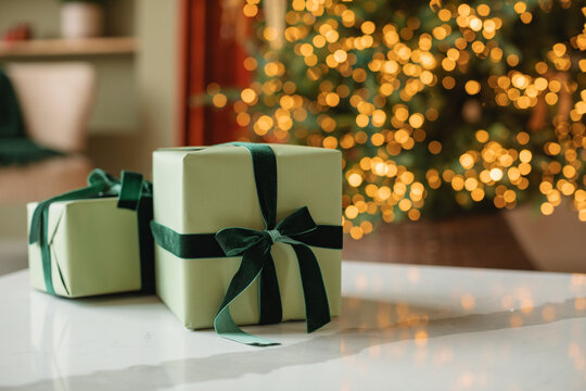 Stack Of Wrapped Christmas Gifts In Front Of An Illuminated Christmas Tree In A Living Room