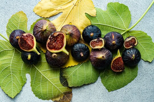 Overhead view of fresh organic figs on an arrangement of fig leaves
