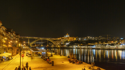 Night view at Ponte Dom Luis seen from Ribeira do Porto with reflection of lights on water surface of Douro River, Porto, Portugal