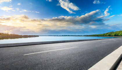 asphalt road highway and lake with sky clouds under the blue sky