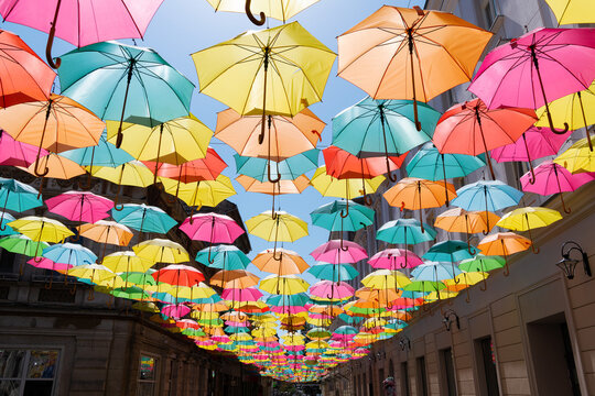 Low angle view of multi coloured Umbrellas hanging over a street, Timisoara, Banat, Transylvania, Romania
