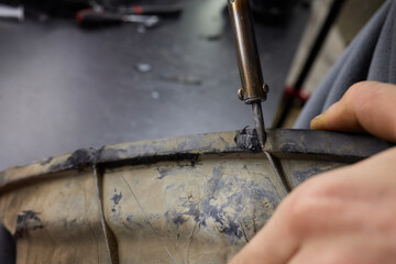 Car headlight in repair close-up. The car mechanic installs the lens in the headlight housing. The...