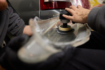 Big headlight cleaning on the car with power buffer machine at service station ,Before and after...