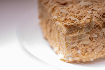 close up view, napoleon cake on light surface, white plate, side view. Place for inscription