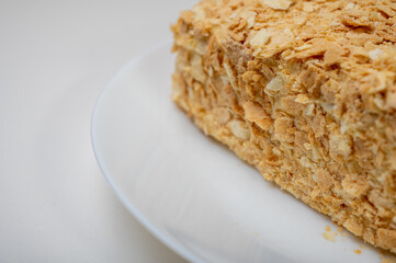 close up view, napoleon cake on light surface, white plate, side view. Place for inscription
