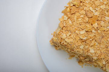 close up view, napoleon cake on light surface, white plate, side view. Place for inscription