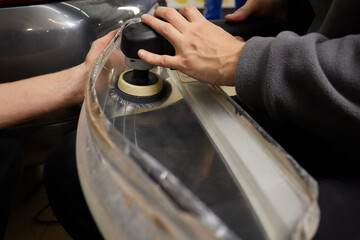Big headlight cleaning on the car with power buffer machine at service station ,Before and after...