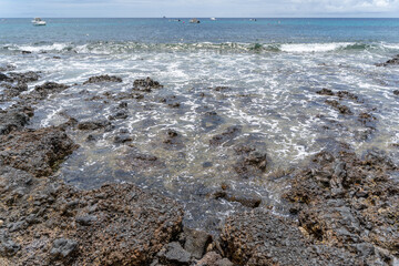 waves breaking on rocks on a beach in lanzarote, spain canary islands