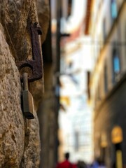 Selective focus shot of an old rusty padlock hanging on a stone wall