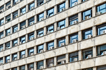 Air conditioning units installed outside an old building windows