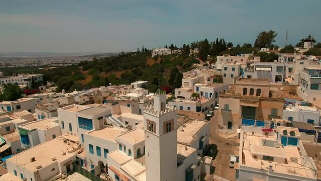 Aerial Panning Shot Of Medieval Mosque In Sidi Bou Said Town On Cliff During Sunny Day - Mahdia, Tunisia