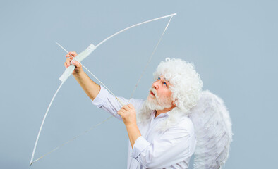 Happy Valentines Day. Bearded man in white curly wig and angel wings shooting love arrow....