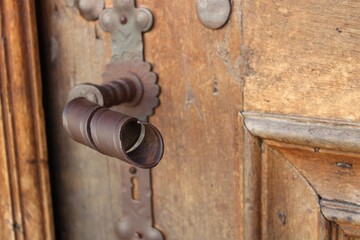 Close-up shot of a rusty door handle on a wooden door