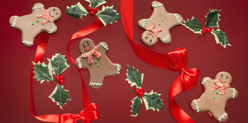 Christmas gingerbread cookies, ribbons and mistletoe on red background