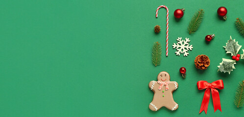 Gingerbread cookie and Christmas decorations on green background with space for text