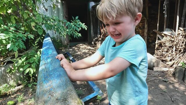 Upset, unhappy child crying in the park. Aggressive boy holding on to the ladder. Concepts about feelings, child psychology, trauma, sadness, tears, disobedience and fear, hysteria, pain, punishment