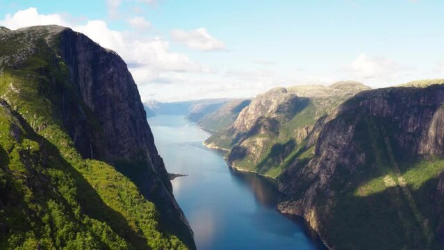 Drone flies in the valley of beautiful Lysefjord Norway with scenic mountains and cliff walls high above the fjord - 4K