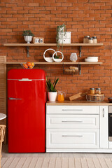 Interior of kitchen with red fridge, counters and shelves