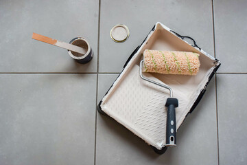 Used painting supplies like a tin can of paint, a paint roller, mixing stick, ...