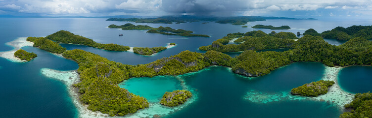 Rain clouds slowly approach the incredible islands of Pef in Raja Ampat, Indonesia. These stunning...