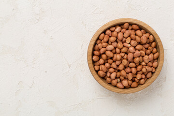 Peeled peanuts on concrete background, top view
