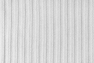 Jersey textile background , white striped knitted fabric. Woolen knitwear, sweater, pullover surface texture, textile structure, cloth surface, weaving of knitwear material. Wallpaper, backdrop.